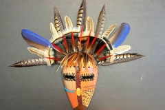 Handcrafted gourd mask with feathered headdress by Donna Vargas