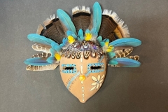 Handcrafted gourd mask with feathered headdress by Donna Vargas